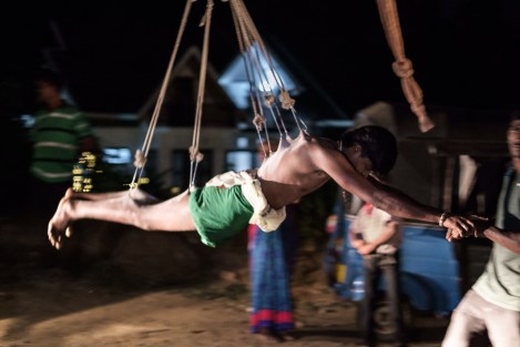 Balanceando a un chico colgado en un Thaipusam